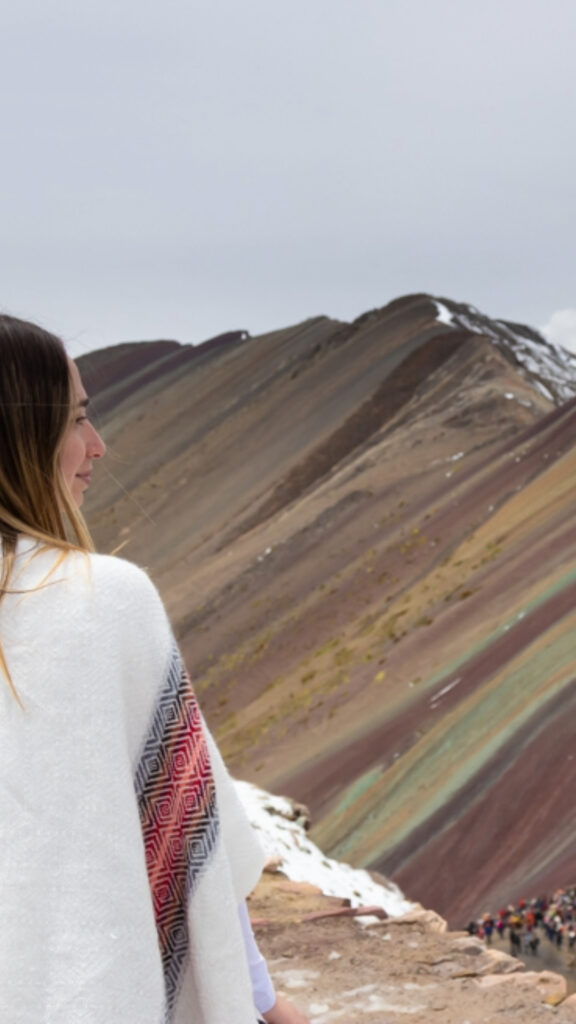 Una vista en primer plano de las franjas minerales diagonales de la Montaña de Siete Colores con una ligera capa de nieve en las cumbres.