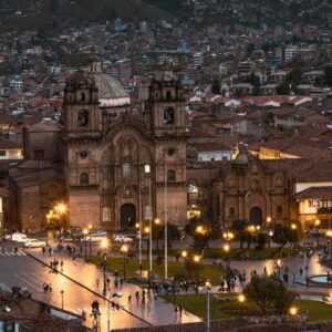 Panoramic high-angle view of the Plaza de Armas during a City Tour Cusco, showing the historic cathedral, colonial architecture, and surrounding Andean hills.