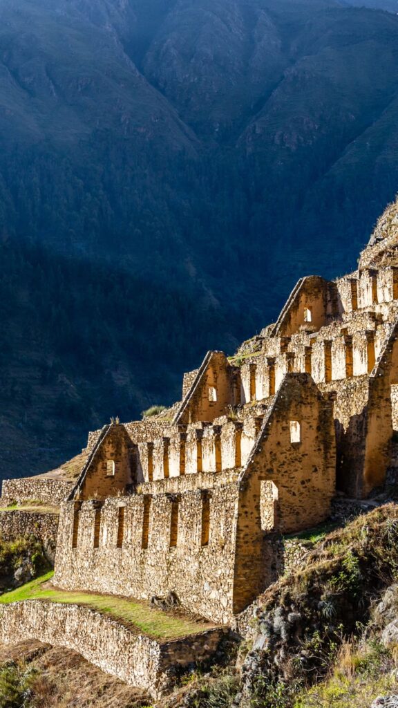 Estructuras de piedra antiguas con techos de paja empinados construidas en los acantilados rocosos que dominan el valle.